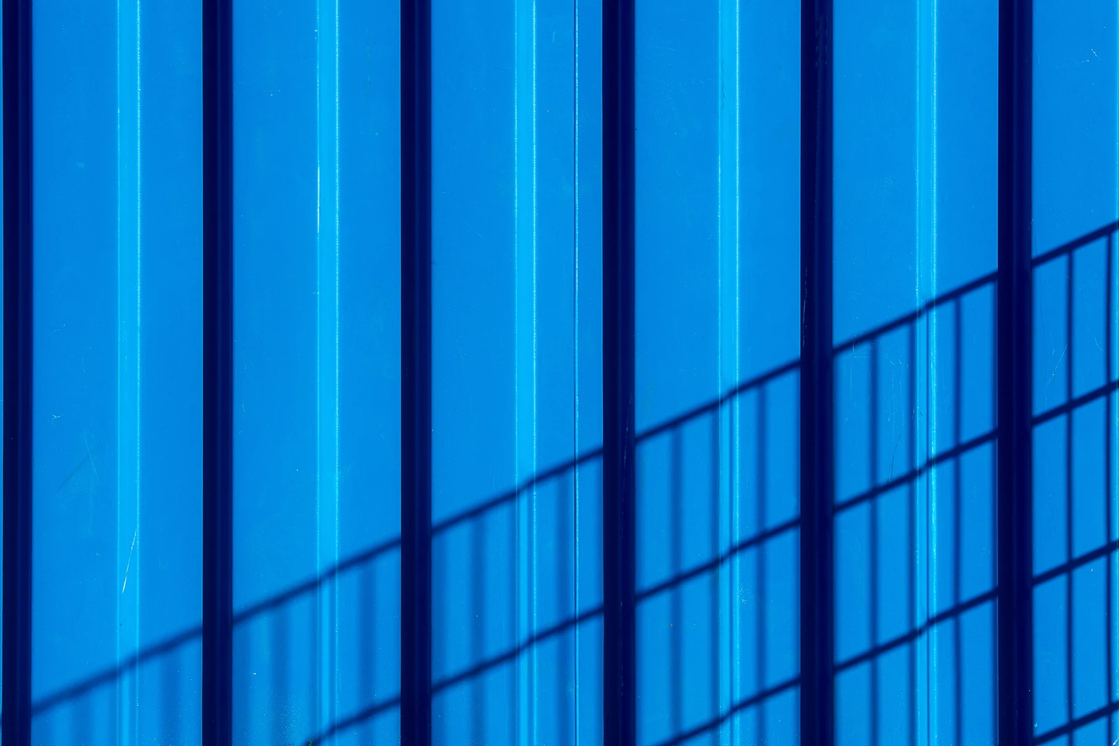 Blå arkitektonisk yta med diagonala skuggor